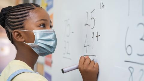 Girl doing math at chalkboard