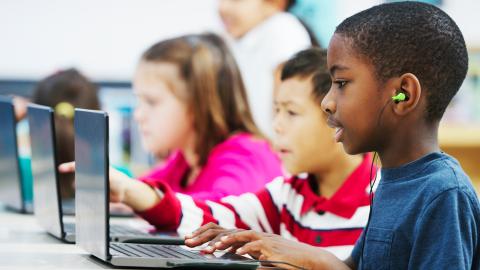 Kids at computers with headphones