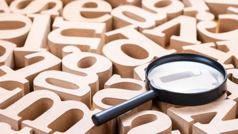 magnifying lens on top of wood letters