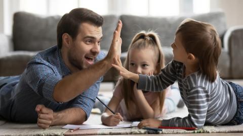 Man and two kids high five doing homework