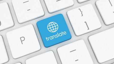 A blue translate button on a white keyboard