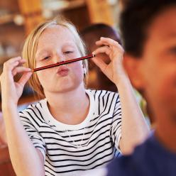 Bored girl in a classroom playing with pencil