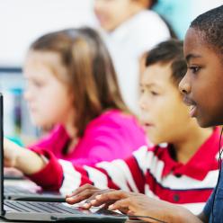 Kids at computers with headphones