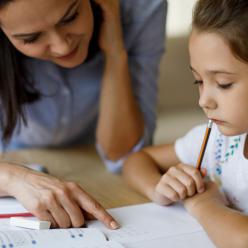 Woman working with girl on schoolwork