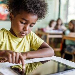 Young student using an iPad at their desk