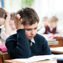 A frustrated boy trying to do work at his desk