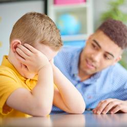 An upset child with an adult trying to provide comfort.