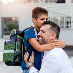 A man smiling while hugging his son