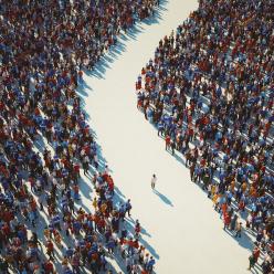 A person walking alone through a parted crowd