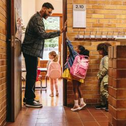 Teacher welcomes students to classroom with a high five