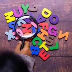 A group of plastic letters and a magnifying glass