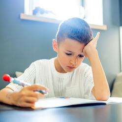 A young child struggling to do school work.
