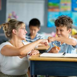Teacher and student fist bumping.