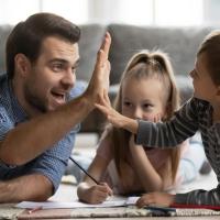 Man and two kids high five doing homework