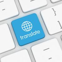 A blue translate button on a white keyboard