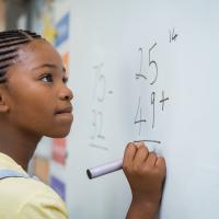 Girl doing math at a whiteboard