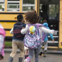 Kids running to a school bus
