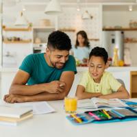 A father is helping his child with homework