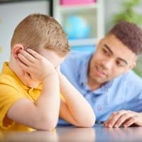 An upset child with an adult trying to provide comfort.