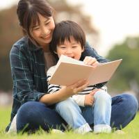 Parent reading to the child in their lap.