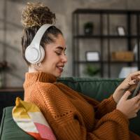 Young adult listening to an audiobook on her phone.